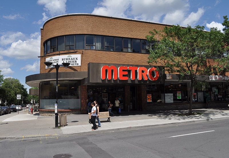 Le 5115 Trans Island à Montréal, un immeuble d'angle en brique avec une épicerie Metro au rez-de-chaussée
